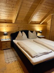 a large bed in a room with wooden ceilings at Berg Chalet 303 in Turracher Hohe