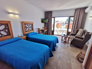 トレモリノスにあるApartamentos La Barandaのベッド2台とバルコニーが備わるホテルルームです。