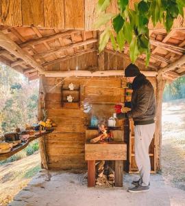 a man standing in front of a stove in a house at Pousada Meu Recanto in Conceição da Ibitipoca