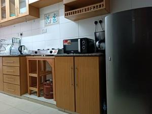 a kitchen with a black refrigerator and wooden cabinets at Stylish 2 bedroom apartment in Nairobi