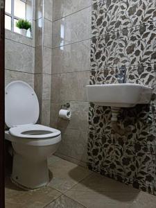 a bathroom with a toilet and a sink at Stylish 2 bedroom apartment in Nairobi