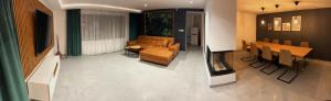 a living room with a couch and a table and chairs at Willa Źródlana in Kowary