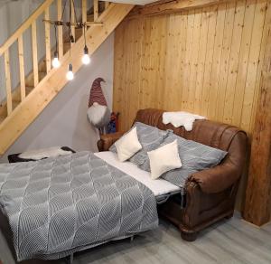 a bedroom with a leather bed and a staircase at Apartmán u Ještěrky se saunou v ceně, Rejvízská 29, Jeseník in Jeseník