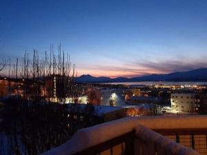 a view of a city at night from a balcony at 36 sqm Studio aparatment B in Tromsø