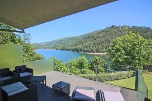 uma vista para um lago a partir da varanda de uma casa em Apartamento Lobo - Casas Barca do Rio - Geres no Gerês