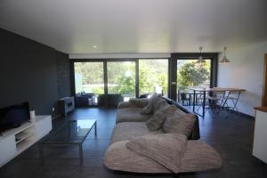 a living room with a couch and a tv at Apartamento Lobo - Casas Barca do Rio - Geres in Geres