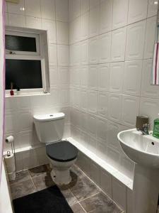 a white bathroom with a toilet and a sink at Cozy home near city, sleeps 5, Free Parking, WIFI in Liverpool