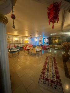 a restaurant with tables and chairs and a rug on the floor at MEVLANA ŞEMS HOTEL in Konya