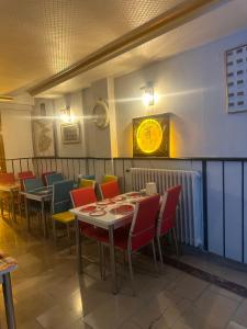コンヤにあるMEVLANA ŞEMS HOTELのテーブルと椅子、壁掛け時計のあるレストラン