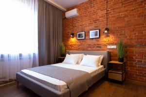 a bedroom with a brick wall and a bed at New studio in the city center – Kharkivska naberezhna 3 in Kharkiv +10 photos
