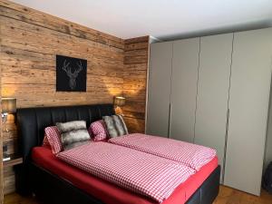 a bedroom with a bed and a wooden wall at Ski-in & Out Alpine Style Apartment near Kitzbühel in Mittersill