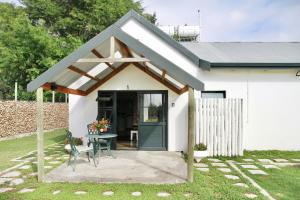 a small white house with a table and a patio at De Hoop Farm - Mountain View in Breërivier +50 photos