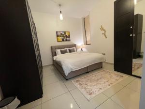 a bedroom with a bed with white sheets and a rug at Sea View 1BR apartment - Marina Pinnacle in Dubai