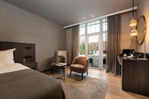 ein Hotelzimmer mit einem Bett, einem Schreibtisch und einem Stuhl in der Unterkunft Hotel Britannia in Knokke-Heist