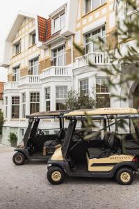 deux voiturettes de golf garées devant un bâtiment dans l'établissement Hotel Britannia, à Knokke-Heist