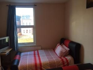 a small bedroom with a bed and a window at Nite Inn Bed & Breakfast in Leeds