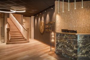 a lobby with a staircase and a counter and a stair case at Hotel Britannia in Knokke-Heist