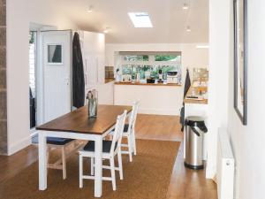 a kitchen and dining room with a table and chairs at Riverside Cottage in Larkhall