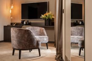 a living room with two chairs and a television at Hotel Britannia in Knokke-Heist