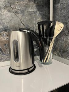 a coffee pot on a counter with utensils at Toscana Apartments in Otopeni