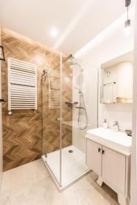 La salle de bains est pourvue d'une douche et d'un lavabo. dans l'établissement Apartament Let's Sea A19 Gąski, à Gąski