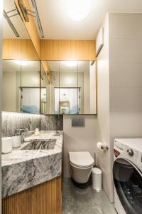 La salle de bains est pourvue d'un lavabo et d'un lave-linge. dans l'établissement Apartament Let's Sea A19 Gąski, à Gąski