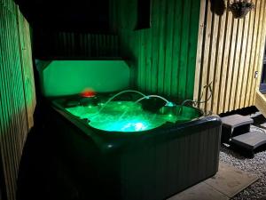 a green bath tub in a room with two chairs at Ramblers retreat in Shrewsbury