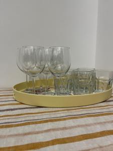 a tray with four empty wine glasses on a table at Toscana Apartments in Otopeni