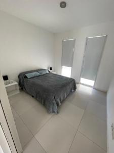 1 dormitorio blanco con 1 cama y 2 ventanas en Moderno departamento de 52 mts en el centro en Comodoro Rivadavia