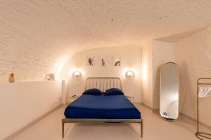 um quarto com uma cama azul num quarto branco em Appartement Le Médicis - 2 chambres em Rouen