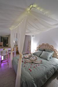 a bedroom with a canopy bed with roses on it at Studios avec piscine ou jaccuzi in Velaux