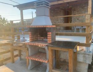 cocina al aire libre con fogones en la terraza en La casa de la valla azul (San Miguel de Langre), 