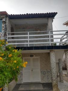 a house with a white door and a balcony at Village Galés Maragogi in Maragogi