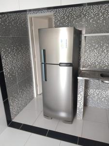 a stainless steel refrigerator in a kitchen with tiled walls at Village Galés Maragogi in Maragogi