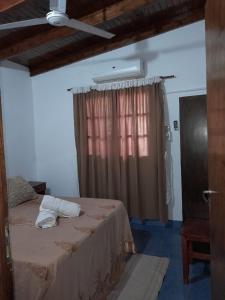 1 dormitorio con 1 cama grande y ventana en IGUAZU CABANAS en Puerto Iguazú