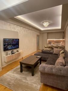 ein Wohnzimmer mit einem Sofa und einem Tisch in der Unterkunft Hills Apartments in Podgorica