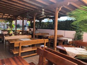 an outdoor restaurant with wooden tables and benches at Arkadia Guest House in Primorsko