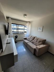 una sala de estar con un sofá y una mesa en EXCELENTE Apto Edifício Santorini, en Maceió