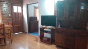 a living room with a flat screen tv on a dresser at Iguazú Cabañas in Puerto Iguazú