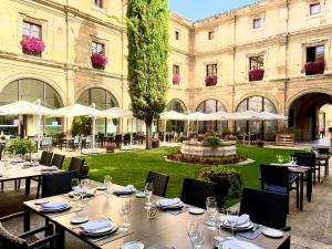 Un restaurante con mesas y sillas frente a un edificio. en Hotel Real Colegiata San Isidoro, en León