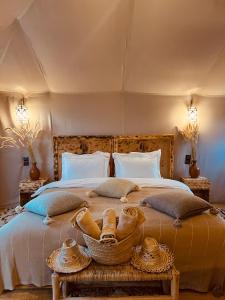 a bedroom with a large bed with baskets on it at Amskou Luxury Desert Camp in Merzouga