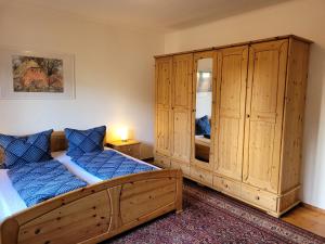 a bedroom with two beds and a large wooden cabinet at Gästewohnung " Am Harsdorf " in Magdeburg