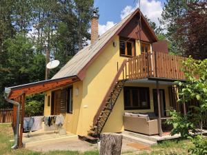 Cette maison dispose d'un balcon et d'une terrasse. dans l'établissement Forest-side home by recreational lake, à Kunfehértó