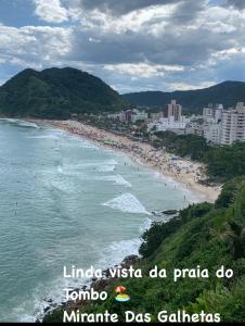 Apto 1 suíte a 30 mts. da Praia do Tombo - Guarujá في غوارويا: اطلاله على شاطئ مع زحمة الناس