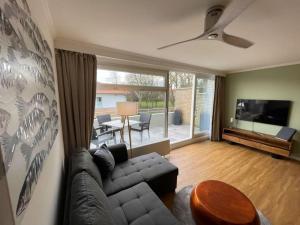 a living room with a couch and a flat screen tv at Sandliebe in Grömitz