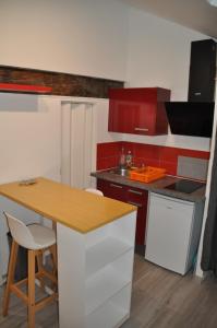 una cocina con armarios rojos y blancos y una mesa en Studio Evian Centre, en Évian-les-Bains