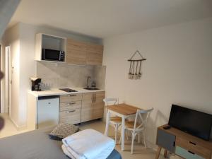 cocina con mesa y cocina pequeña con comedor en STUDIO Cannes Marina, en Mandelieu-la-Napoule