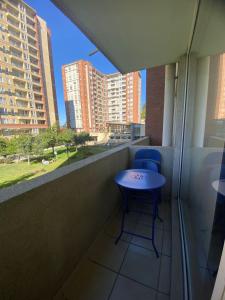 a balcony with two blue chairs and a table at Parque urbano in Concepción