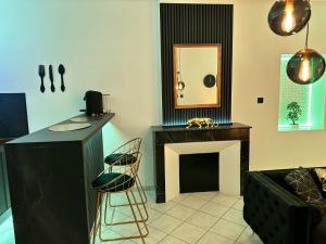 een woonkamer met een open haard en een spiegel bij Le Gold&Black proximité de Metz 