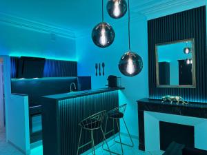 een blauwe keuken met een aanrecht en krukken bij Le Gold&Black proximité de Metz 